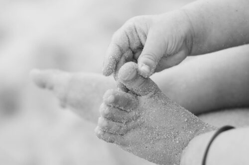 close up of baby s sandy feet at beach